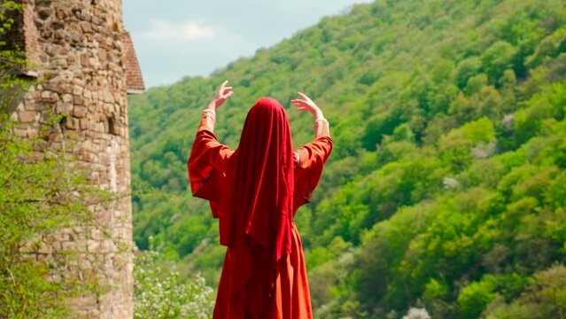 A girl in a national Georgian red dress is dancing. Selective focus.