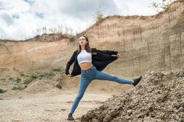 caucasian female model poses in sand quarry with blue sky, in summer sunny day