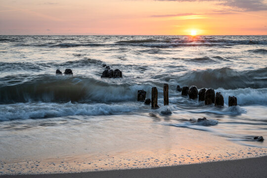 Germany, Schleswig-Holstein, Rantum, Beach groyne at sunset with clear line of horizon over North Sea in background