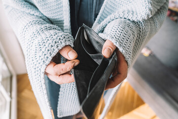 Hands of man wrapped in blanket holding empty wallet
