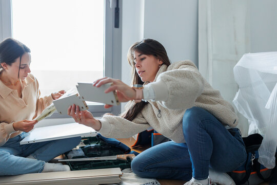 Young lesbian couple installing new furniture together at home