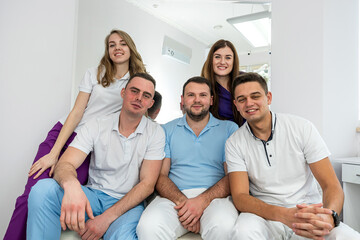 Five young promising experienced masters of dentists pose in the hallway.