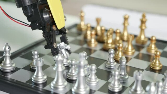 Closeup yellow robot arm playing move chess on chessboard, STEM education E-learning, Technology science robot education concept