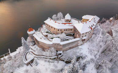 Lake Bled on a beautiful winter morning with mist and vivid clouds at sunrise