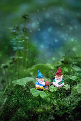 little toy gnomes  in mystery fairytale forest, abstract blurred dark green background. magic...