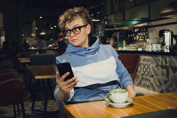 stylish woman casual wear portrait in public cafe - working with mobile