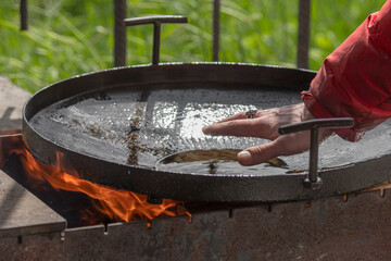 Hot oil for frying. Heated pan. Cook over a campfire. Street wok for cooking fried food. Picnic...