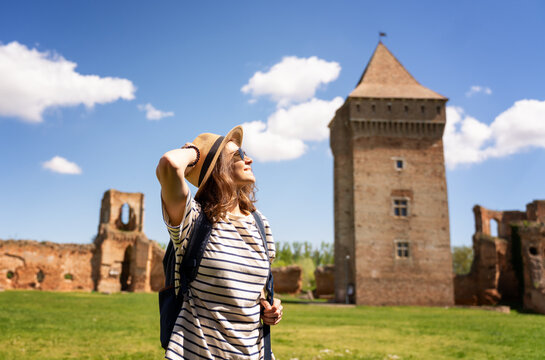 Young happy woman traveling around Serbia, against the background of a medieval fortress in Bac city