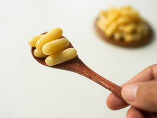 Royal jelly capsules on wooden spoon. Organic Supplement Propolis from Honey Bee. Natural Food...