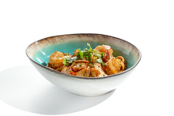 Pan asian food - udon with prawn, chicken wok on white background. Noodle with chicken and prawn in ceramic bowl. Indonesian wok with udon noodles. Spicy thai dish from noodle with shrimp and chicken.