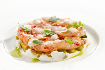 Fototapeta na wymiar Restaurant dish - shrimp tartare with avocado, cream cheese, sweet chilli sauce on white plate. Ceviche with marinated prawn, avocado and spicy vegetables. Prawn tartare isolated on white background.