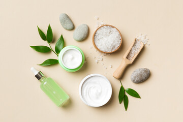 Coconut with jars of coconut oil and cosmetic cream on colored background. Top view. Free space for...