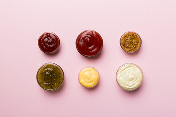 Different types of sauces in bowls on a colored Board . Top view. various sauces copy space
