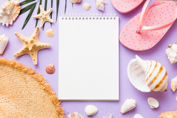 Blank writing book with summer beach accessories on background, copy space. Flat lay with copy space