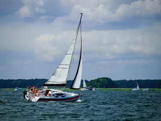 Sailboat sailing on a lake in a windy sunny summer day