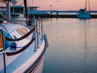 moored sailing yacht hull and pier, dawn waterscape view
