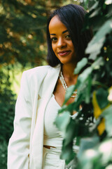 potrait of a black woman with white blazer in nature