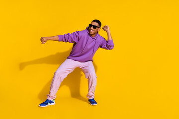 Fototapeta na wymiar Full length body size view of attractive cheerful cool guy having fun dancing clubbing isolated over bright yellow color background