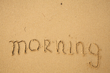 Morning - handwritten on the soft beach sand.