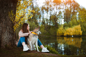 female dog walker with a pet walking in nature by the river.