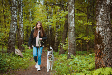 female dog walker with a pet walking in nature by the river.