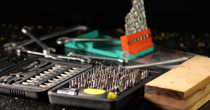 A of metal steel heads and bits with different types for screwdriver, man hand put one in the workshop