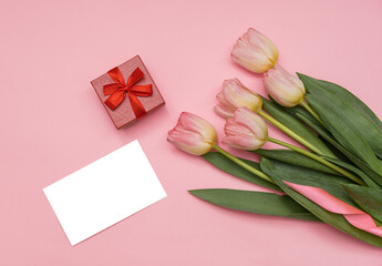 Pink tulip bouquet, blank greeting card and gift boxes. Top view. Copy space