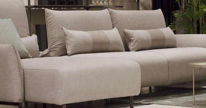 Close Up Modern Gray fabric sofa. Textile upholstery sofa with pillows. Modern Loft Apartment, Beautiful white sofa in the modern living room. Modern Sofa in Confortable Home. Scandinavian interior.