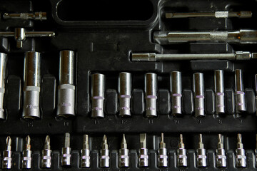 Open set box with working tools different types of metal steel heads and bits at the workshop, Interchangeable screwdriver set.