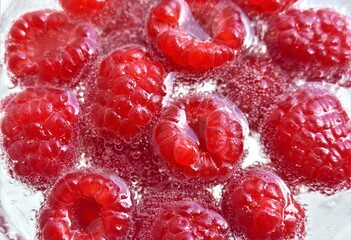 Raspberries in the water with bubbles