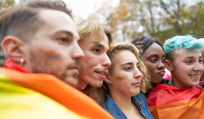 Young activists for lgbtq+  and human rights with rainbow flag manifesting in the city - Gay and lesbian community fighting for his rights