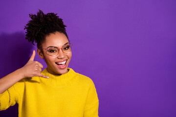 Portrait of attractive funny girl arm fingers demonstrate call me isolated on purple color...