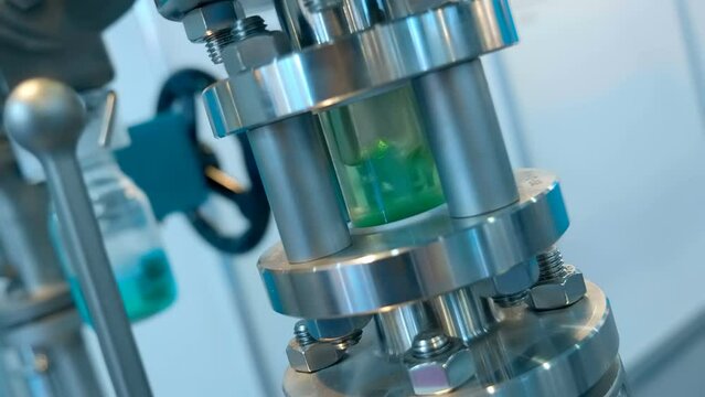 For better visual control, a glass transparent segment is integrated in the pipeline for pumping liquids in the medical, chemical, cosmetic industries. Closeup. Shot in motion