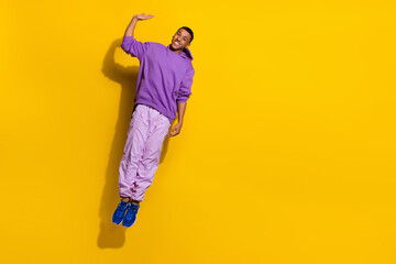 Fototapeta na wymiar Full length body size view of attractive trendy cheerful guy jumping having fun waving hi isolated on bright yellow color background