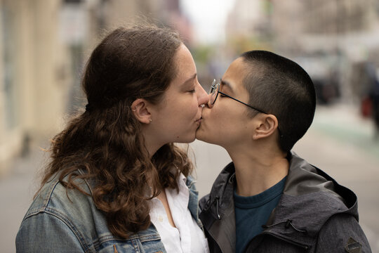 LGBTQ couple on city street kissing