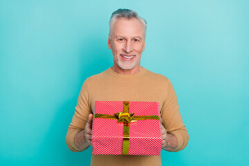 Portrait of handsome good mood cheerful male give you birthday present wrapper box isolated on teal color background