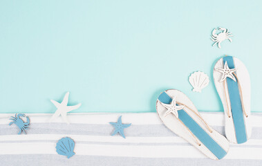 Blue colored summer and holiday background, flip flops, sea stars and fish with copy space, travel and tourism concept
