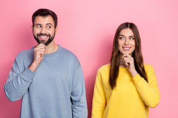 Portrait of attractive cheery couple deciding new strategy thinking isolated over pink pastel color background