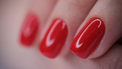 Female hand with red bright glossy varnish