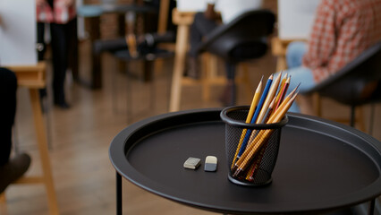 Colorful pencils and erasers on table in art class studio, to practice sketch drawing. Artistic tools used to draw masterpiece on canvas and learn creative skills in workshop. Close up