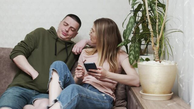 Happy online retail web services buyers make easy purchase, instant money transfer, use secure remote e payment concept. Couple in love sit on sofa with laptop holding credit card buying on internet