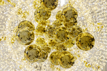 Composition of golden shiny sparkling Christmas balls on the background of luminous garlands. Defocused image. Festive postcard background