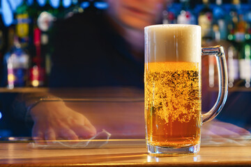 Fresh cold beer in glass on bar background