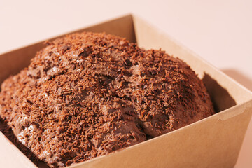 Chocolate cake turtle in box without lid on pink background.