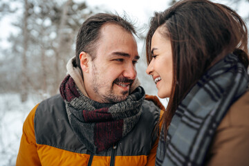 Fototapeta premium Young couple in love outdoor in snowy winter forest.