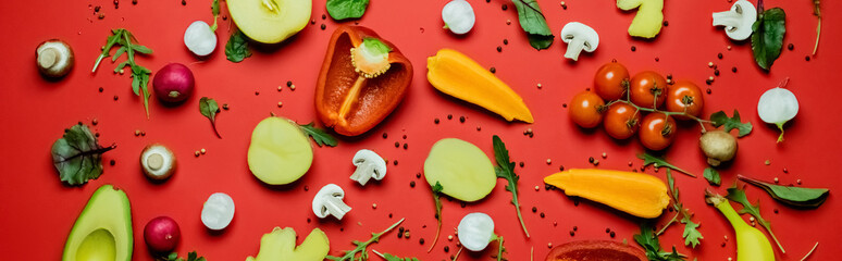 Top view of ripe vegetables, fruits and peppercorns on red background, banner.