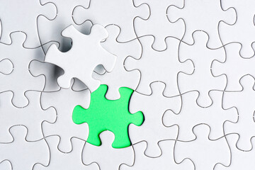 Fototapeta premium Piece of jigsaw puzzle on green paper. Flat lay, Directly above.
