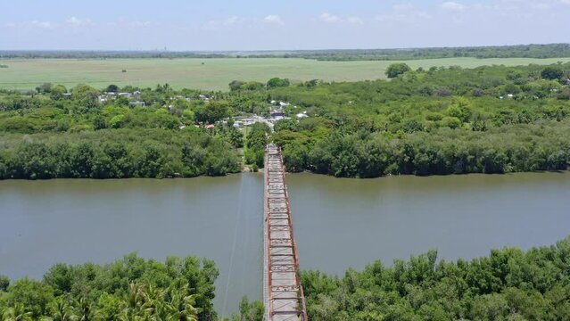 Old Bridge Over Peaceful River Of Soco At San Pedro de Macoris In Dominican Republic. Aerial Pullback Shot