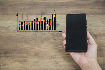  financial and investment technology concept men's hands are active Smartphone to plan stock chart...