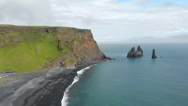 Aerial Orbiting drone Iceland Reynisfjara Black Sand Beach with Basalt Columns